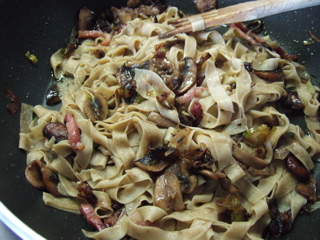 Aggiungere dei funghi e unire la pasta ancora al dente